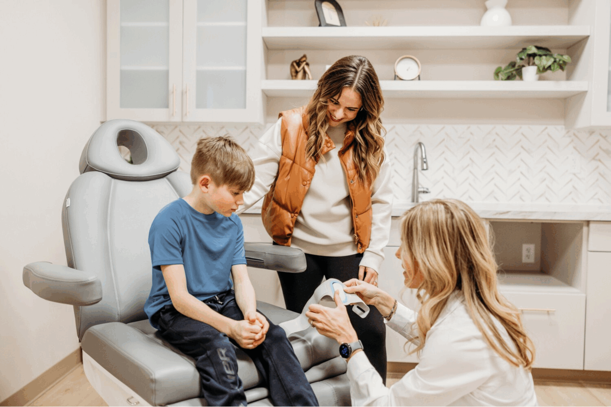 Headache specialist showing a young boy and his mother a treatment device during a visit at Transcend Headache Clinic.