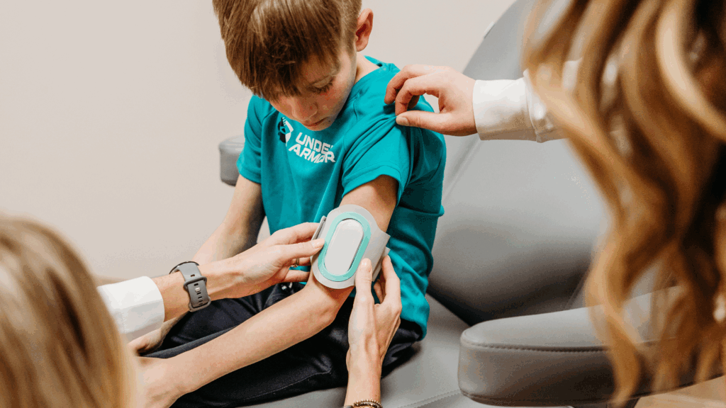 Young patient using Nerivio®, a neuromodulation device, as part of migraine and headache treatment at Transcend Headache Clinic.