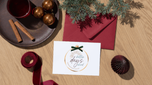 Flat-lay of holiday items including cinnamon sticks, ornaments, ribbon, and a Transcend Headache Clinic “Better Days Ahead” holiday card.