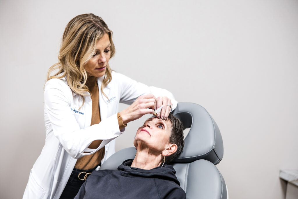 Headache specialist administering Botox injections for chronic migraine treatment during an in-office appointment.