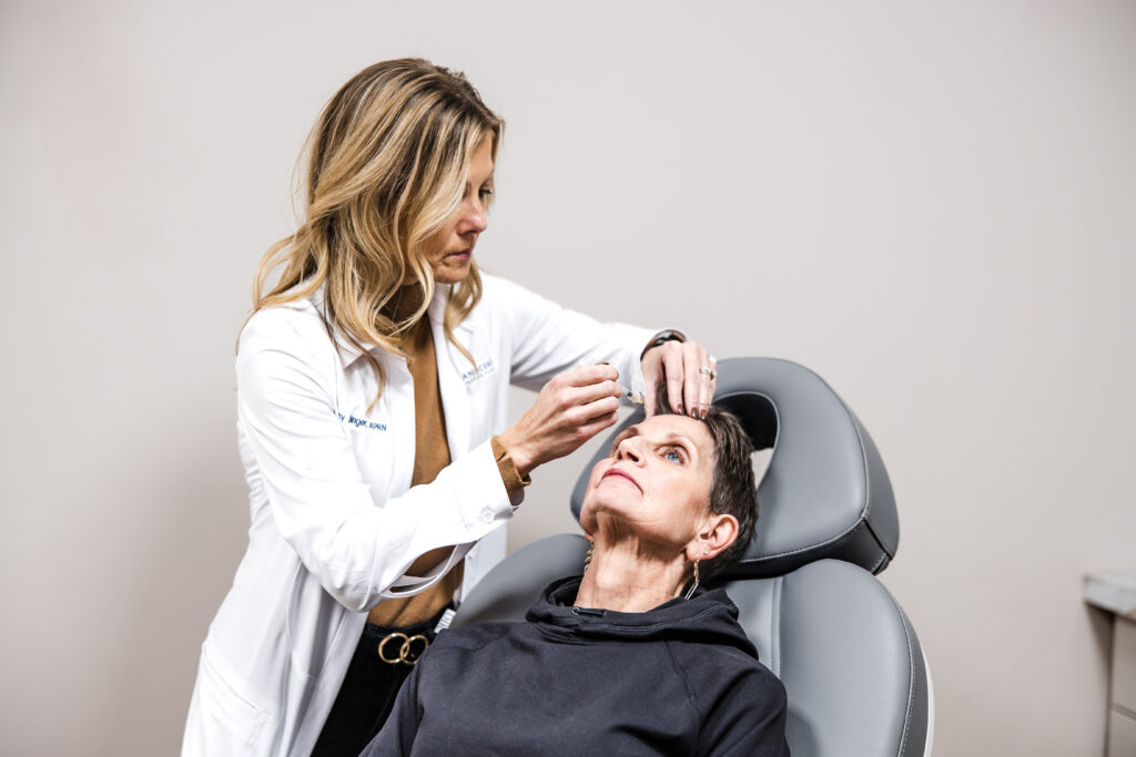 Provider administering Botox injections for migraines to patient during treatment session.