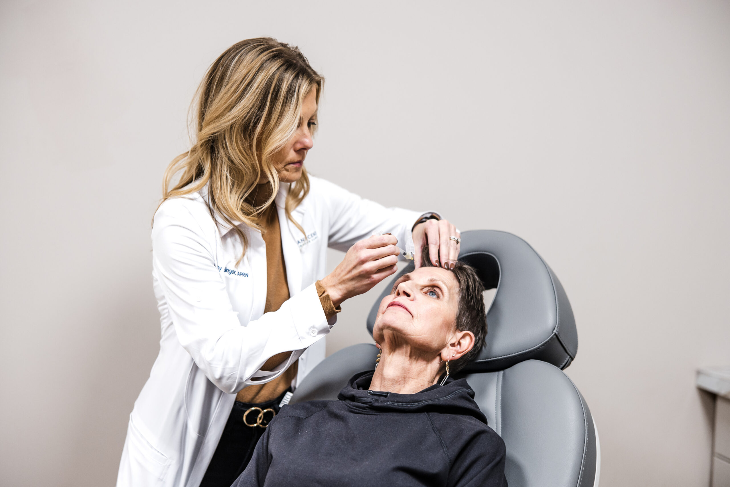 Provider administering Botox injections for migraines to patient during treatment session.